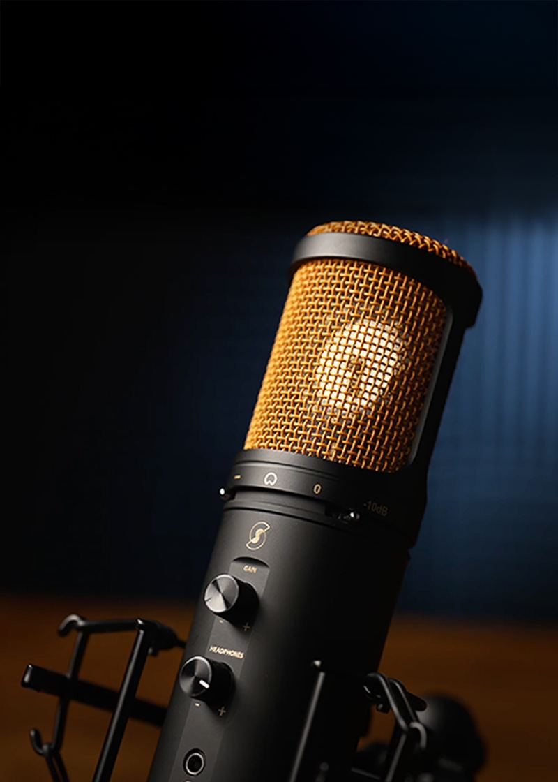 A close-up of an Editors Keys SL600 black studio microphone with a gold mesh grille, mounted on a stand against a dark blue and black background.